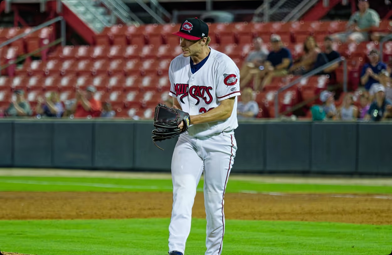 A professional pitcher coming set on the mound in front of a full stand.